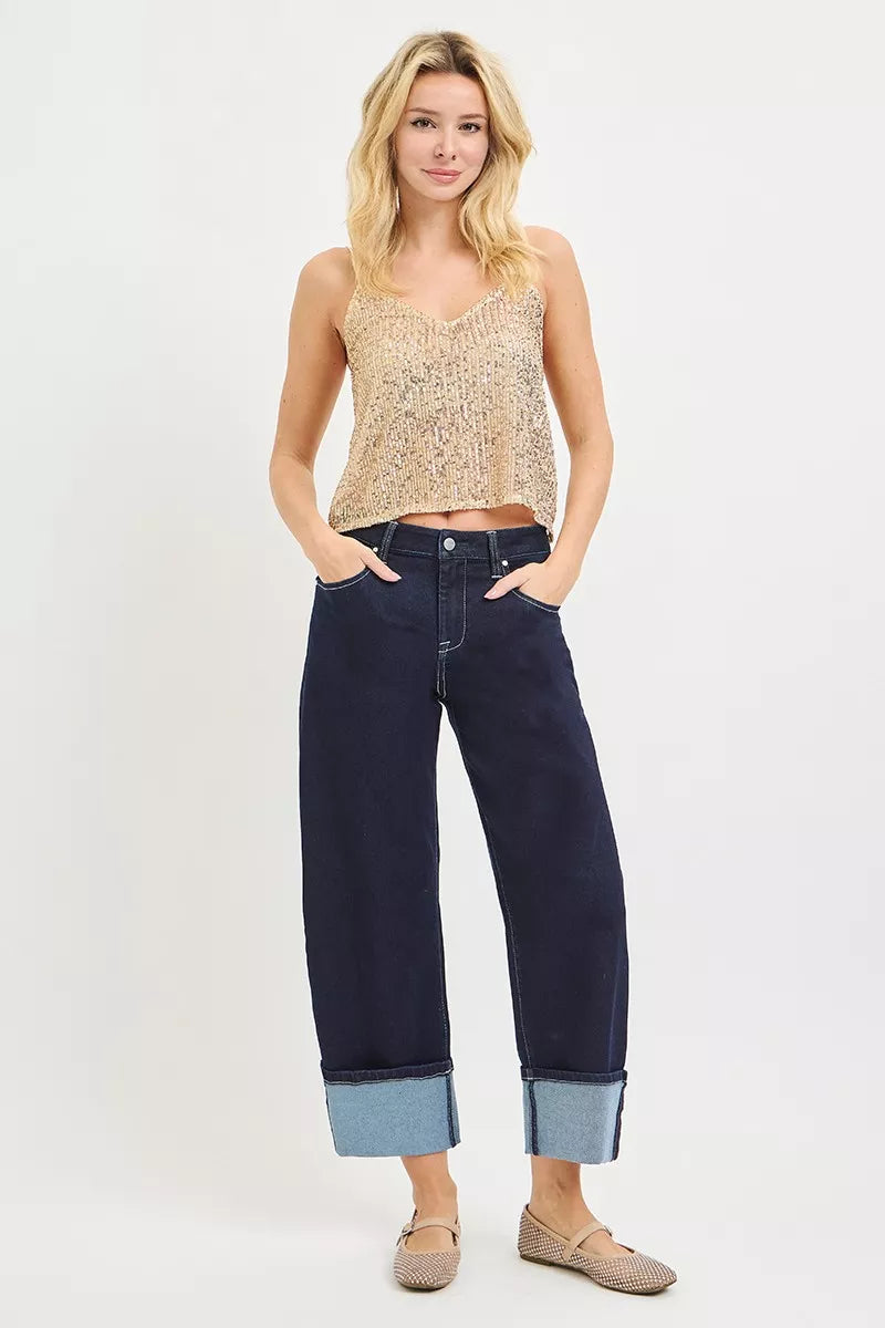 Model wearing dark wash slouchy crop barrel jeans with cuffed hem and five-pocket design