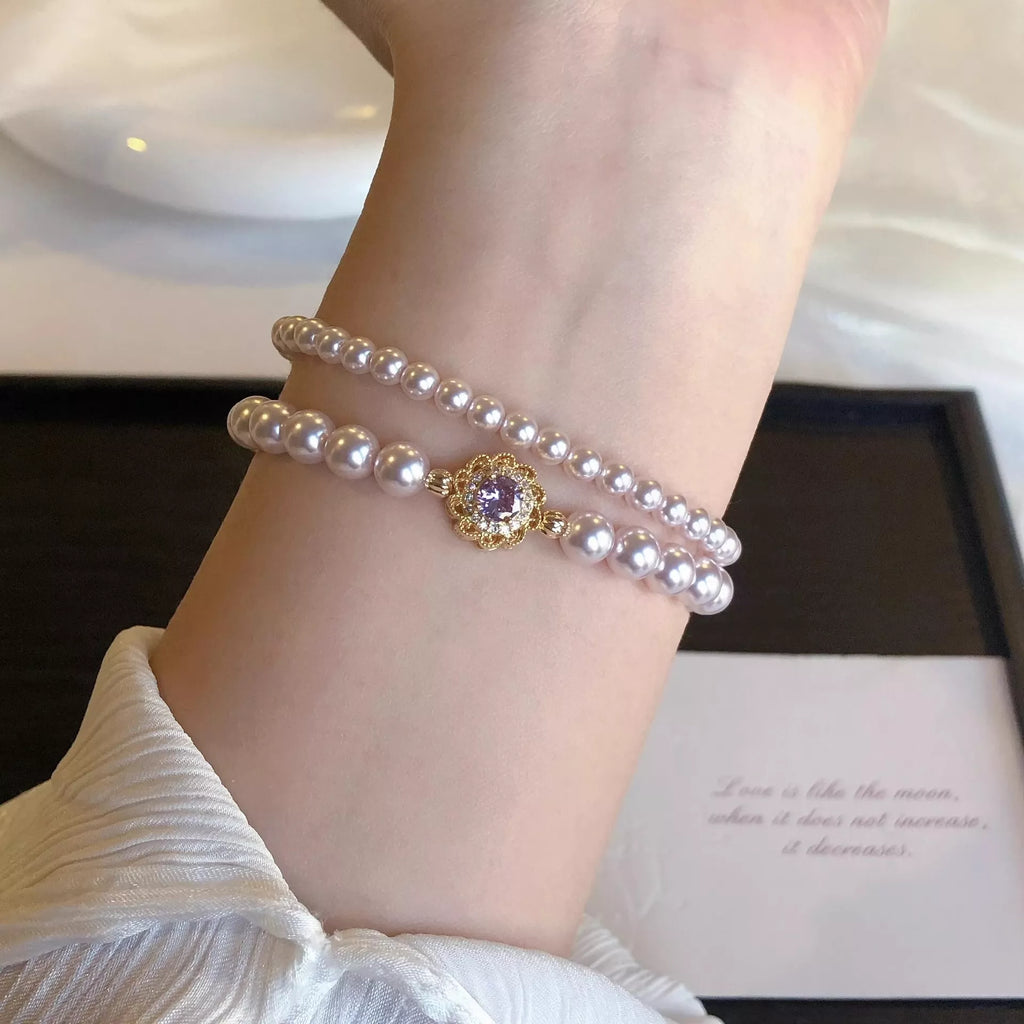 18K Gold-Plated Pearl Bracelet on wrist with double pearl strands and gold flower charm