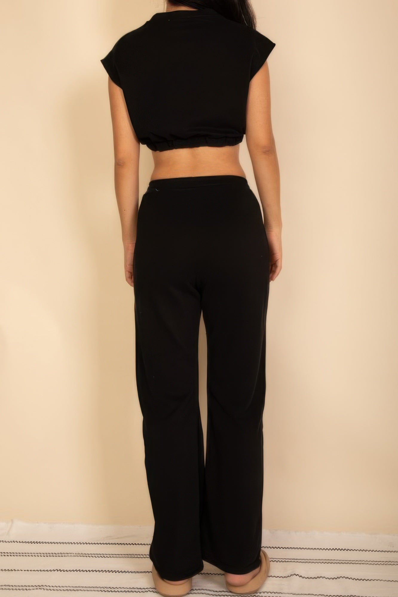 Black back view sleeveless crop top and wide-leg pants with elastic waist
