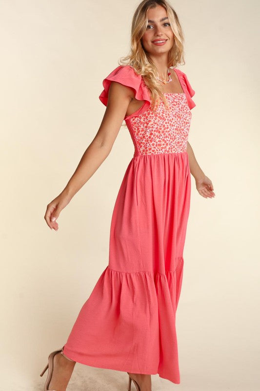 Coral maxi dress with embroidered dot bodice and tiered skirt, angled side view