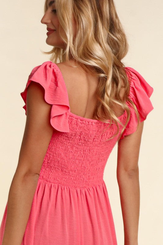Coral embroidered dot dress close-up of open back and ruffled shoulder detail