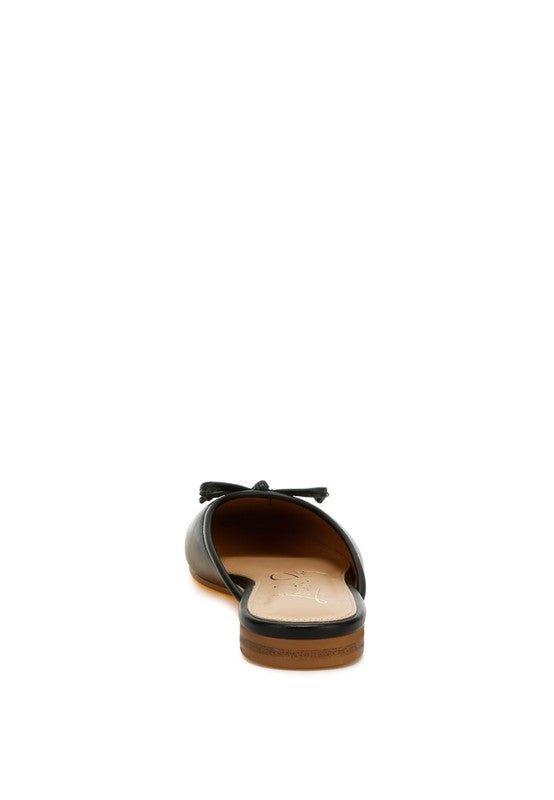 Black slip-on flat mule back view, open heel and bow detail