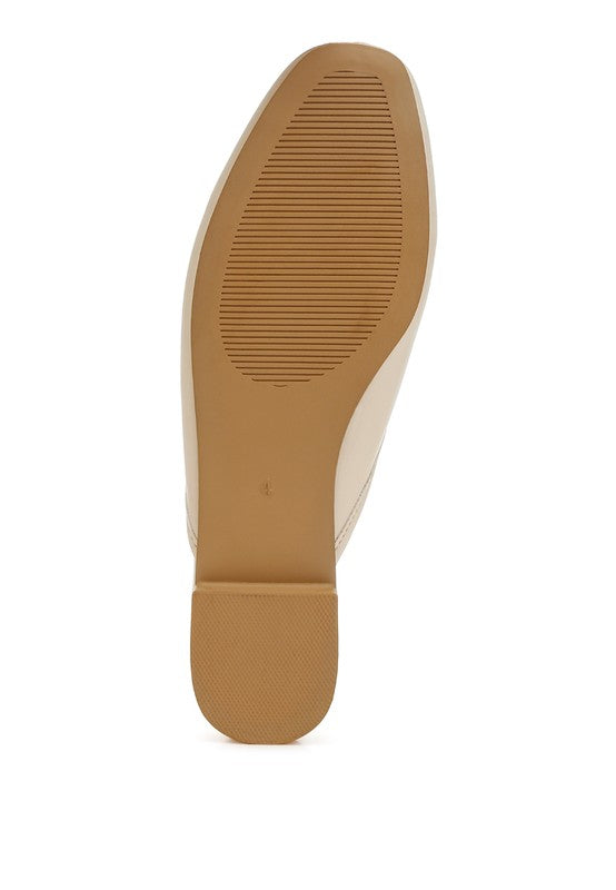 Beige flat mule outsole view, textured tread on the bottom