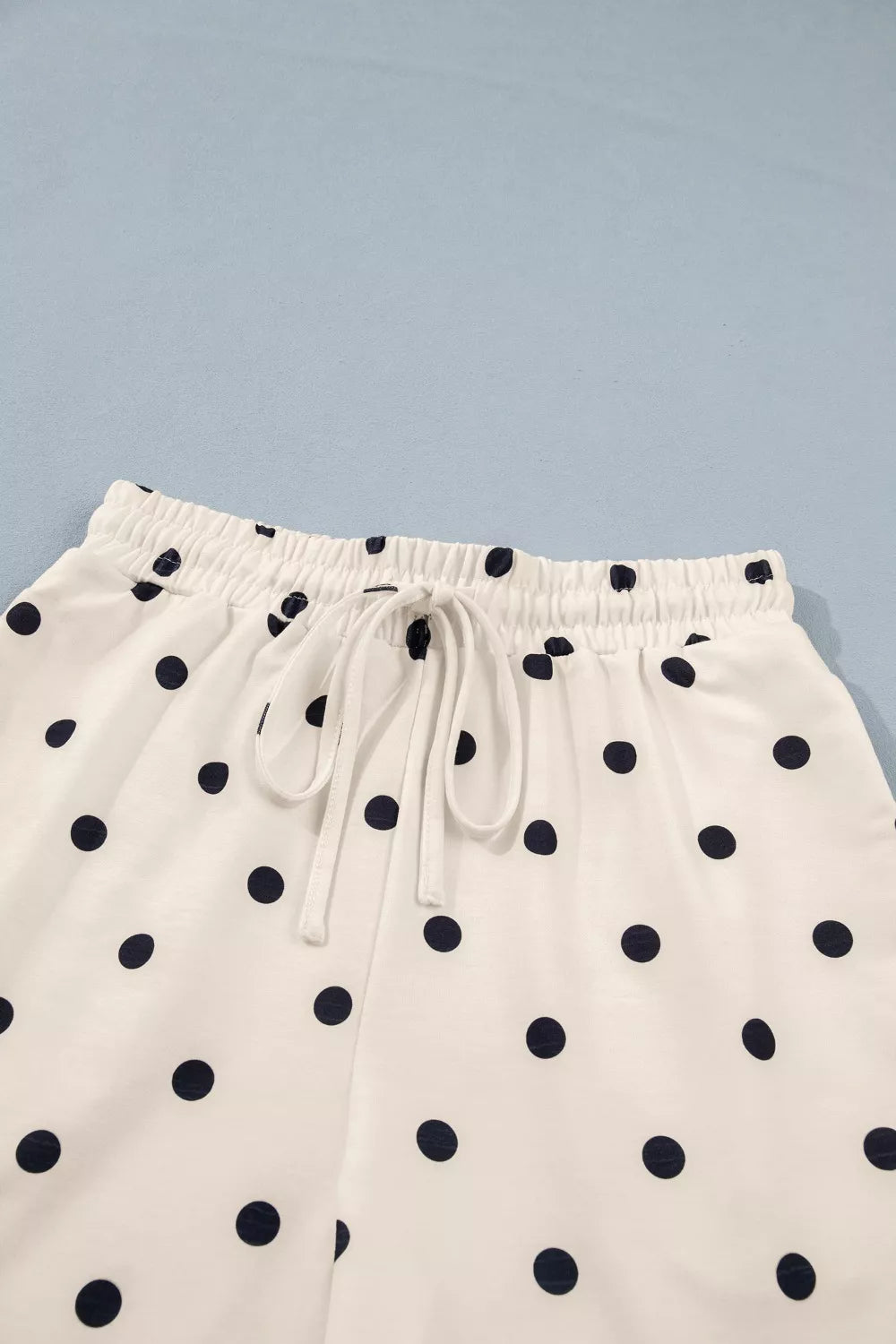 Cream polka dot shorts with elastic waistband and tie drawstring