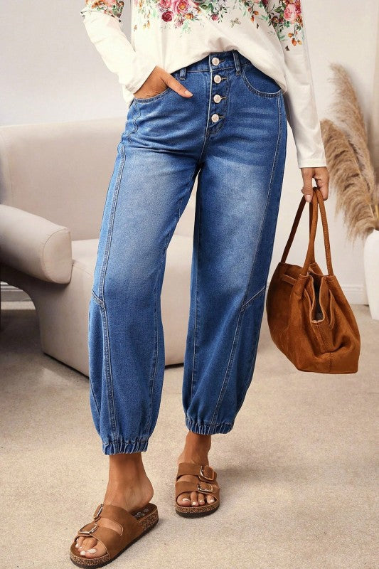 Blue denim jeans with buttoned fly and tapered barrel leg, front view