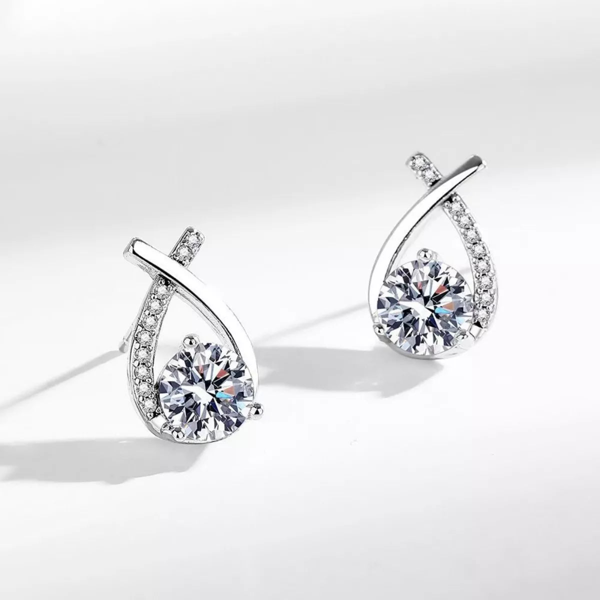 Moissanite teardrop earrings, side view, pavé frame with round center stone