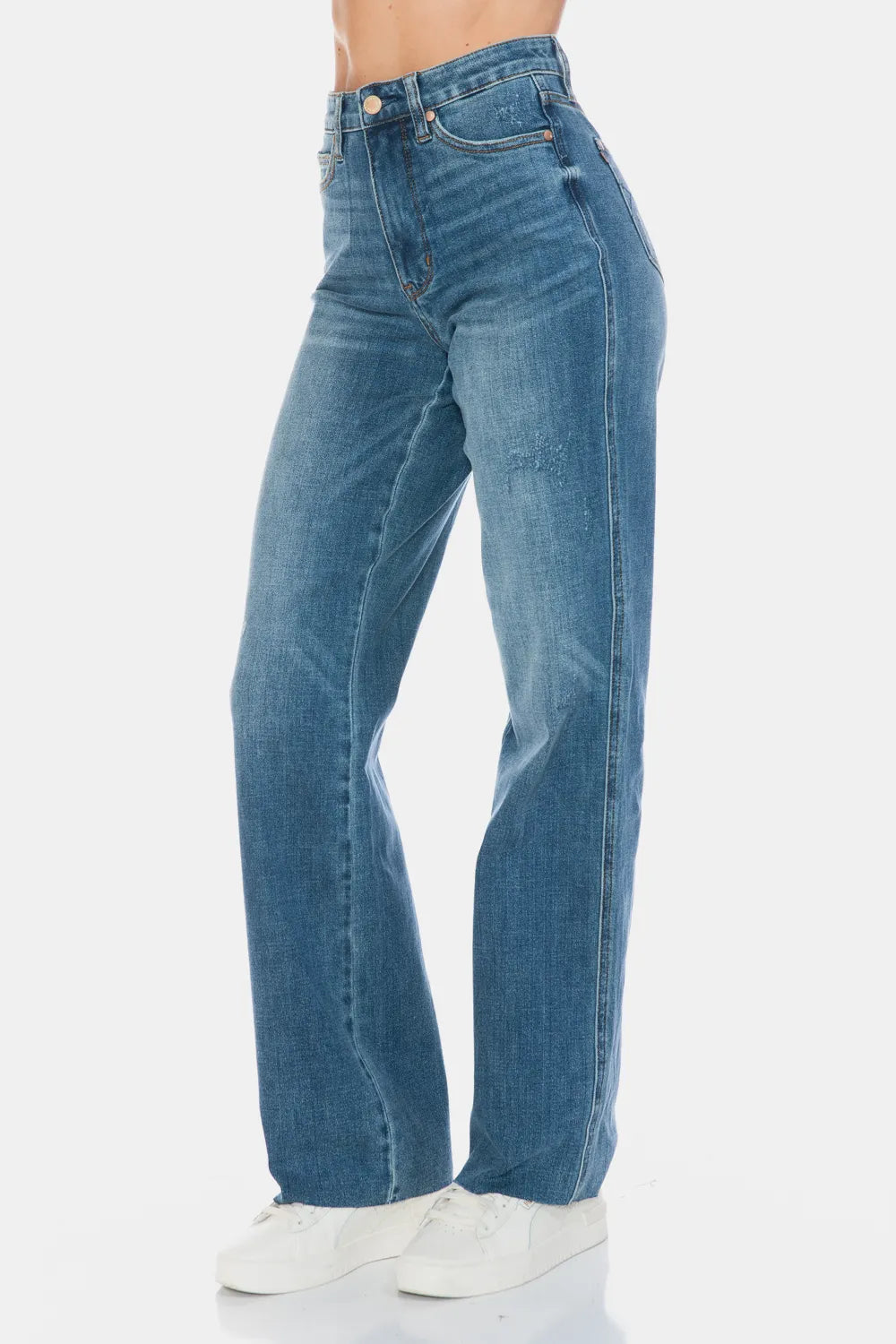 Medium-wash straight jeans side view showing seams and raw hem