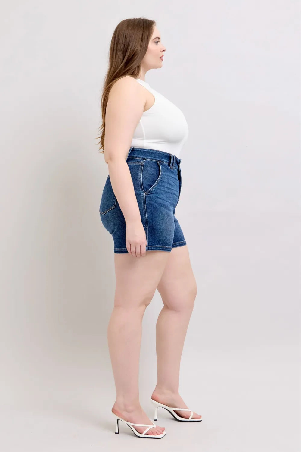 Dark denim plus-size shorts with back pocket and belt loops, side profile