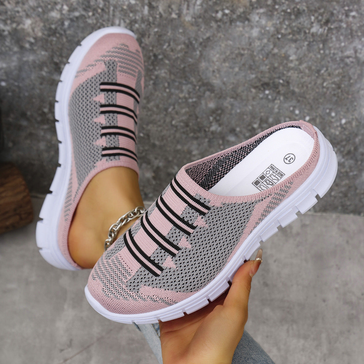 Pink knit slip-on sneakers with black striped pattern and cushioned white sole
