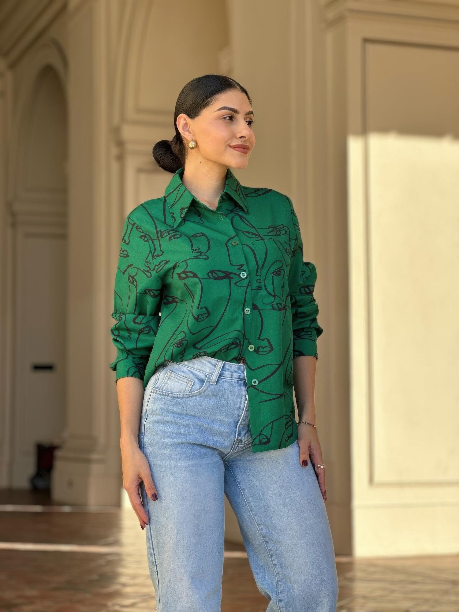 Green face-print long-sleeve button-up blouse with collared neckline and front buttons