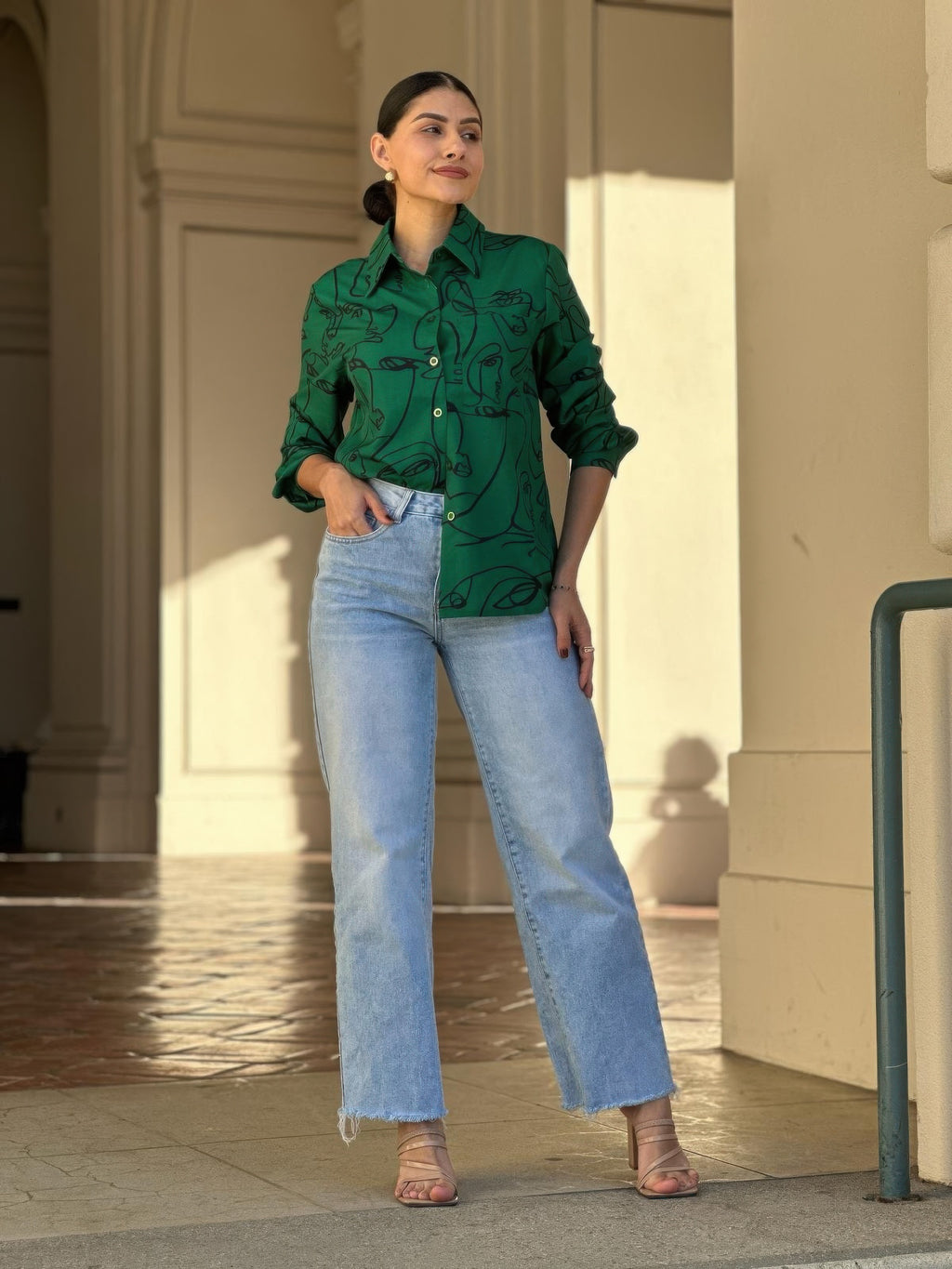 Green long-sleeve button-down blouse with face graphic print, buttoned front and cuffs