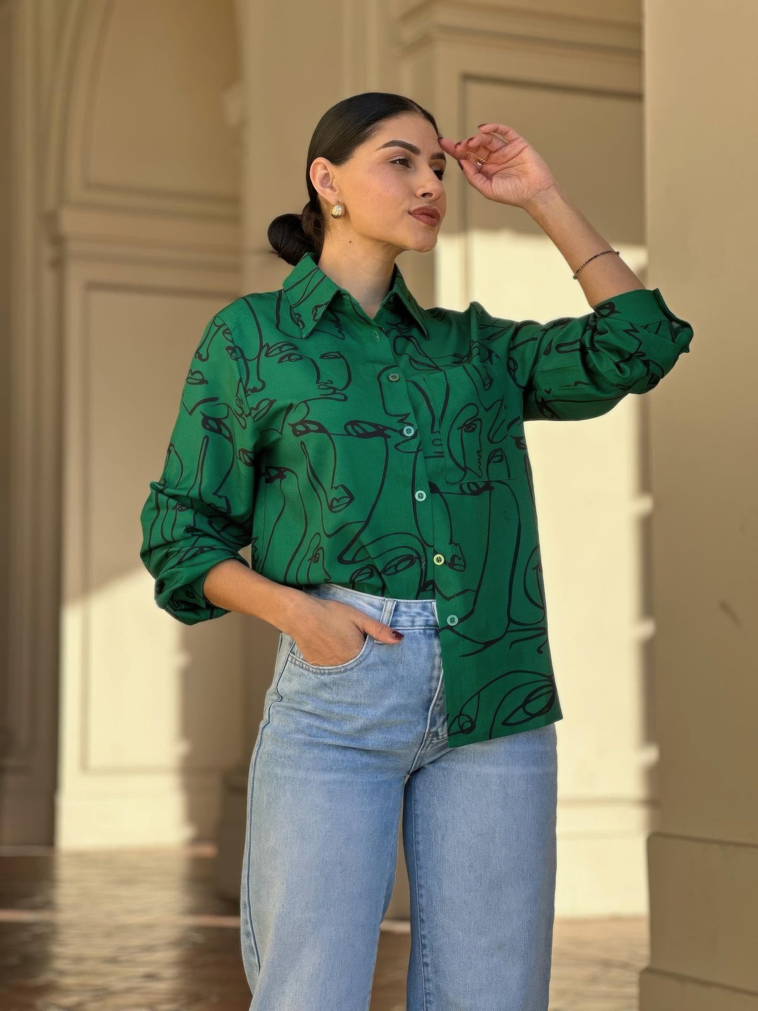 Green graphic face-print button-up blouse with long sleeves and buttoned front