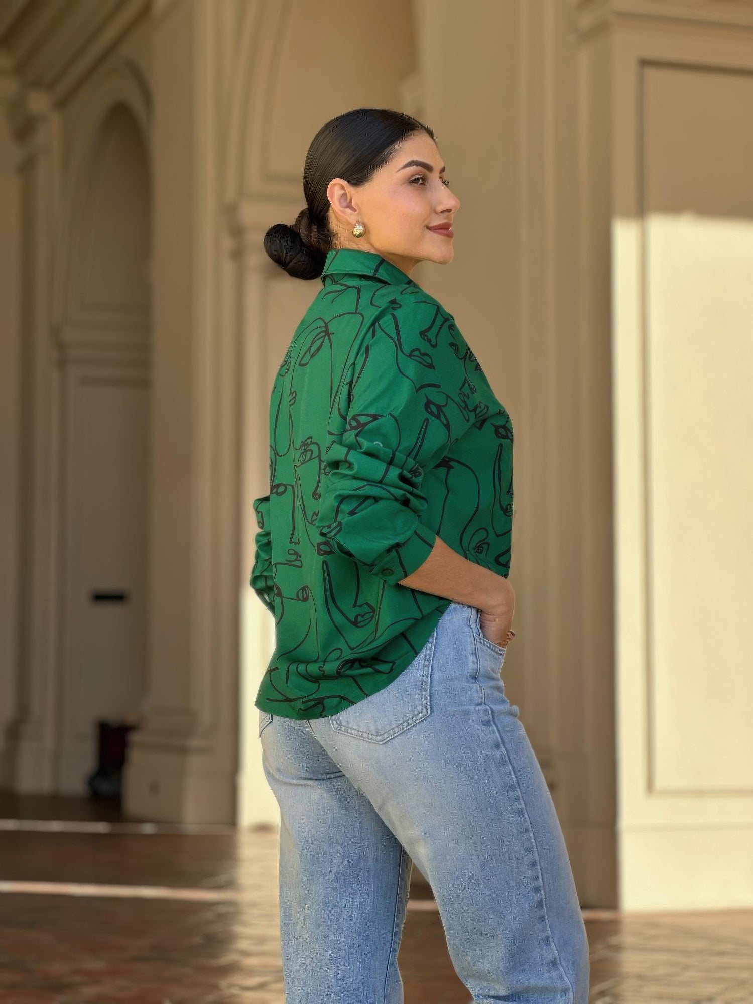 Green face-print button-down blouse from side view with long sleeves and collar