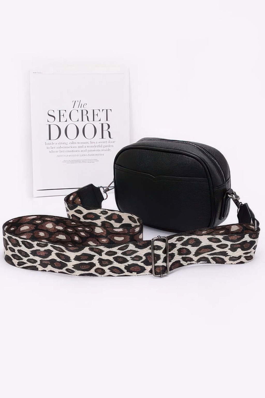 Black faux leather camera bag with leopard print strap and silver buckle