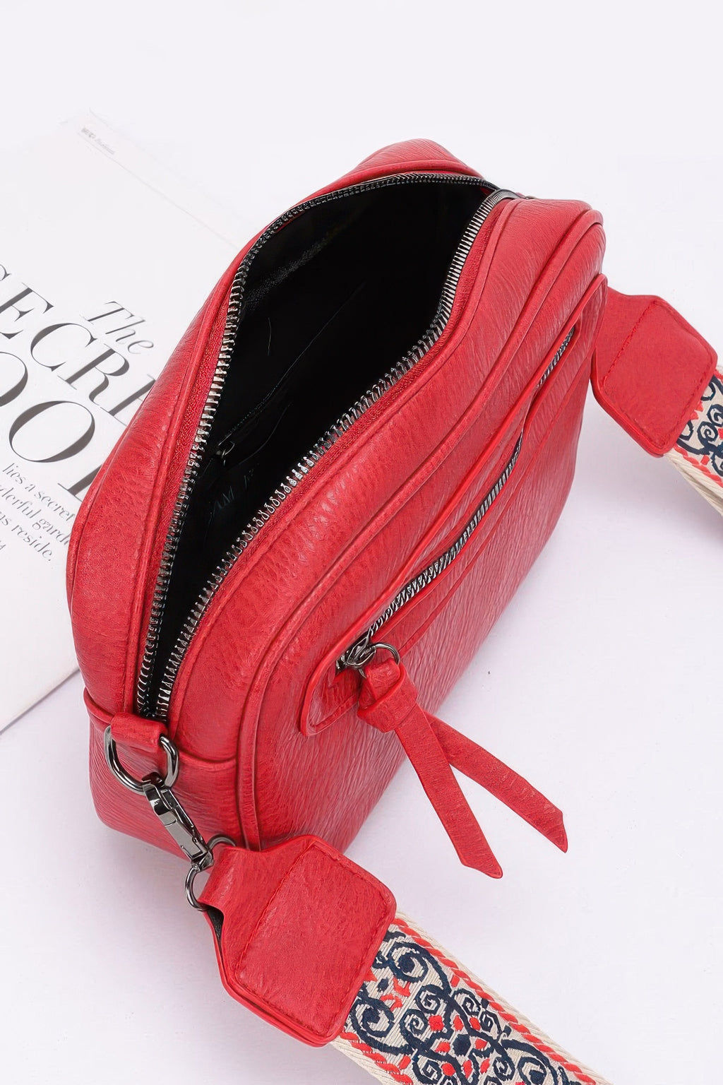 Red faux leather camera bag open view with zip closure and strap connectors