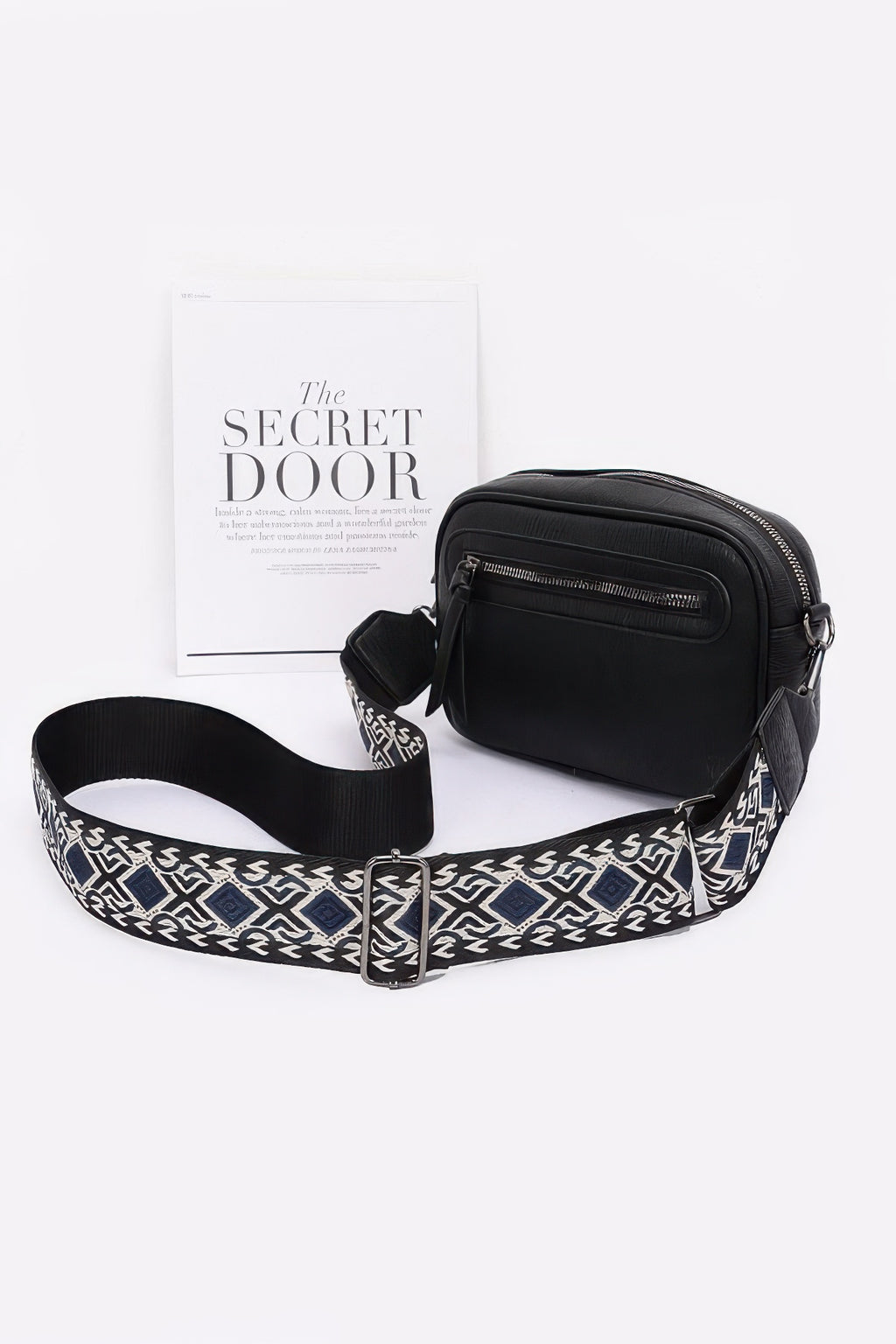 Black faux leather camera bag with zip pockets and patterned crossbody strap