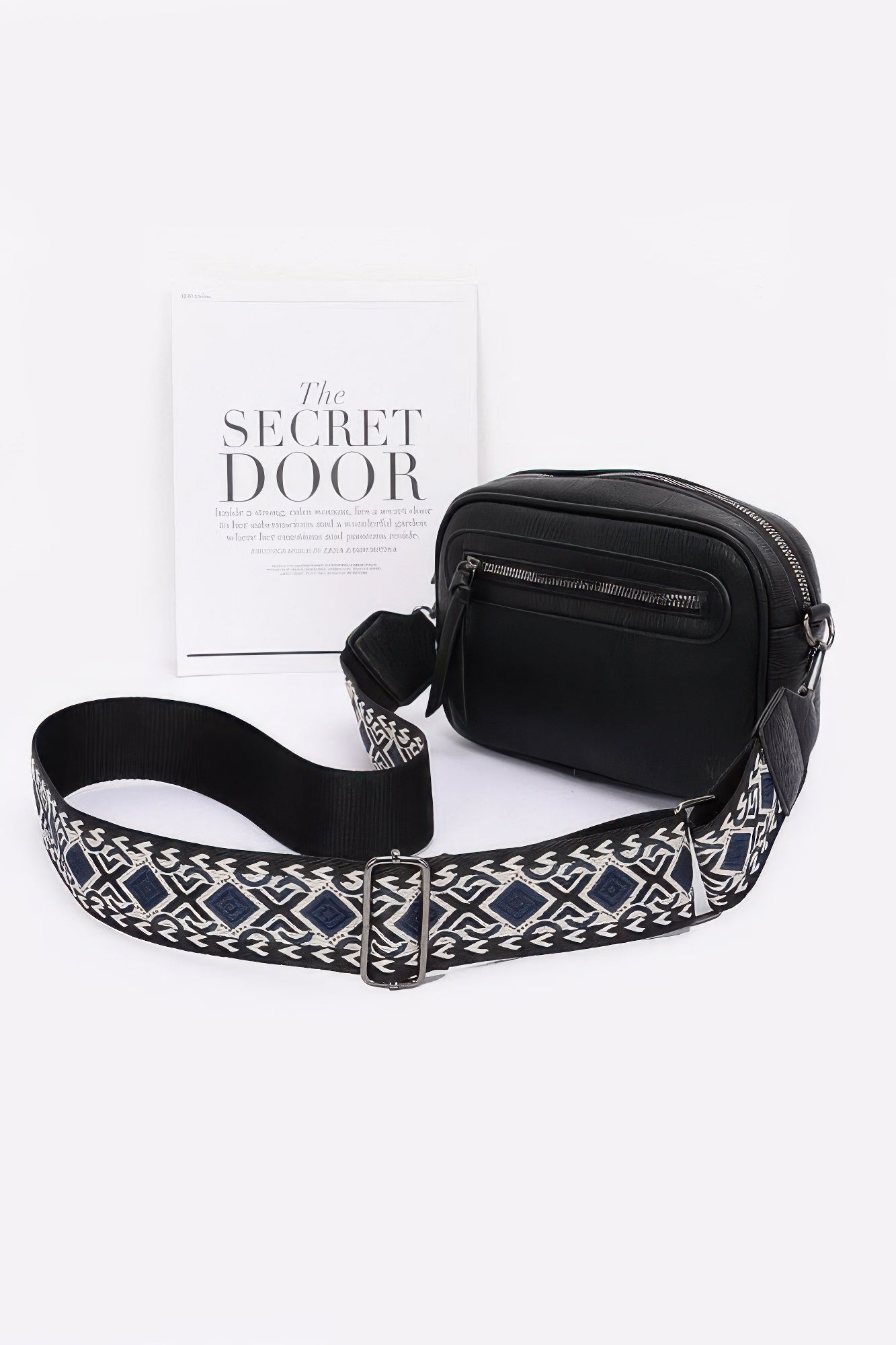 Black faux leather camera bag with zip pockets and patterned crossbody strap