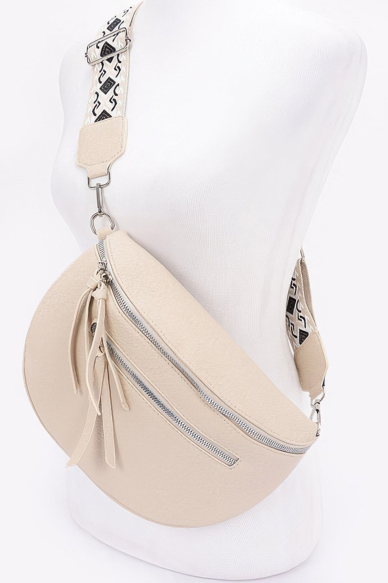 Beige crossbody bag with front zipper and tassel pull details; key clip ring.