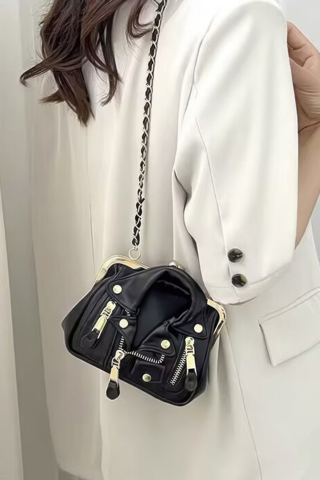Black faux leather crossbody bag with gold-tone hardware, chain strap and zip front