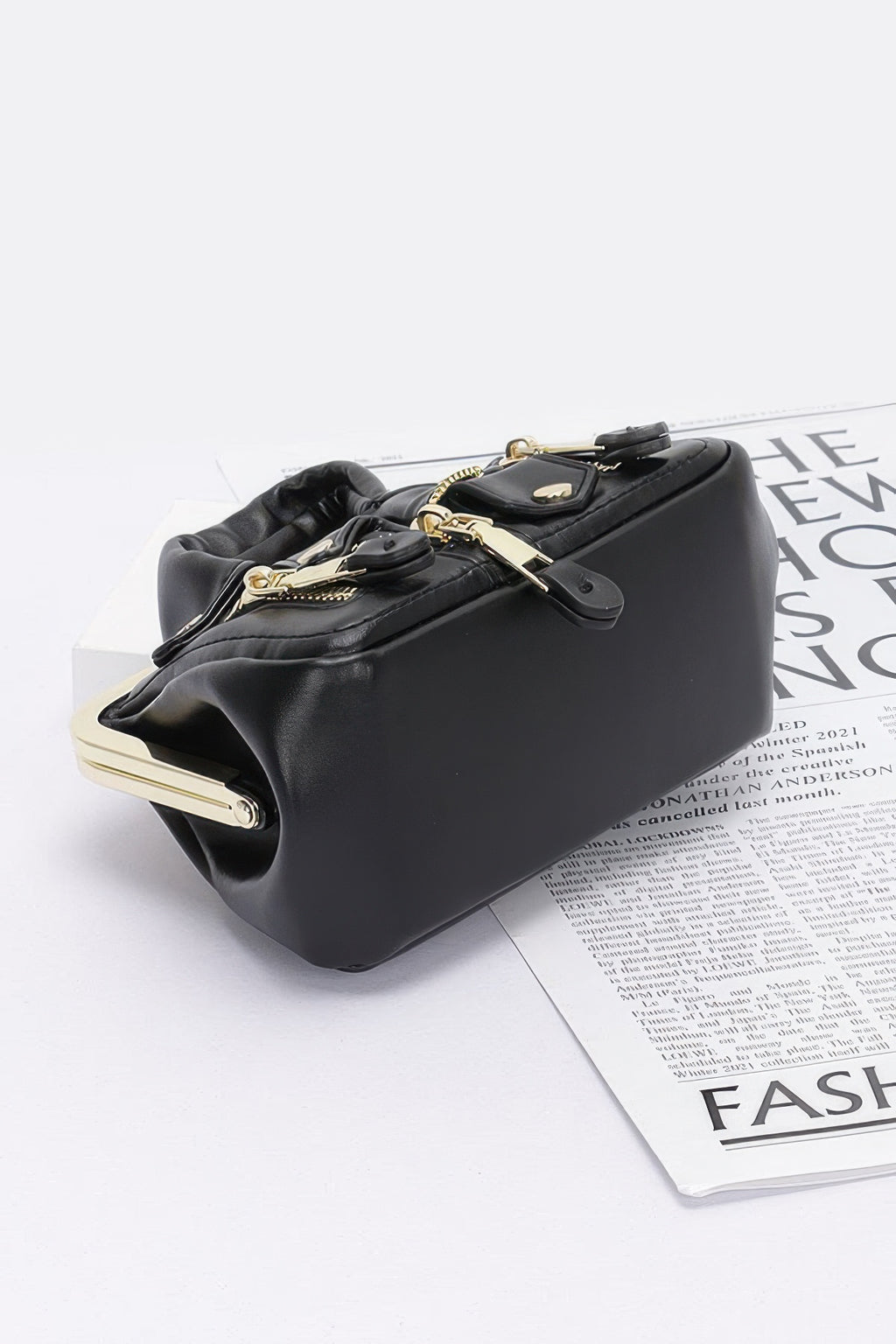 Black faux leather crossbody bag, gold-tone chain and clasp top frame