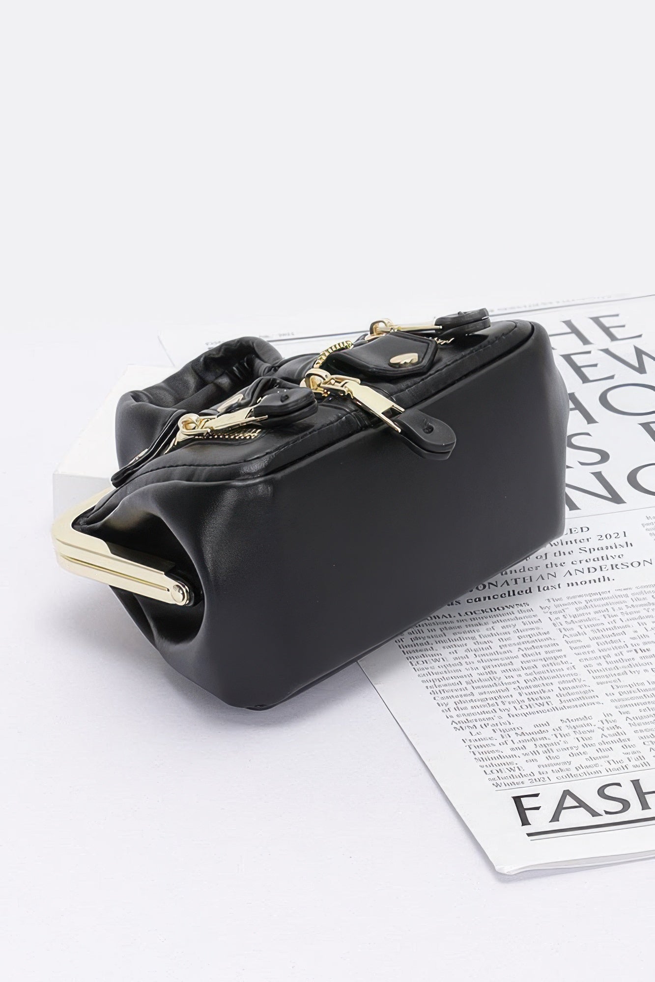Black faux leather crossbody bag, gold-tone chain and clasp top frame