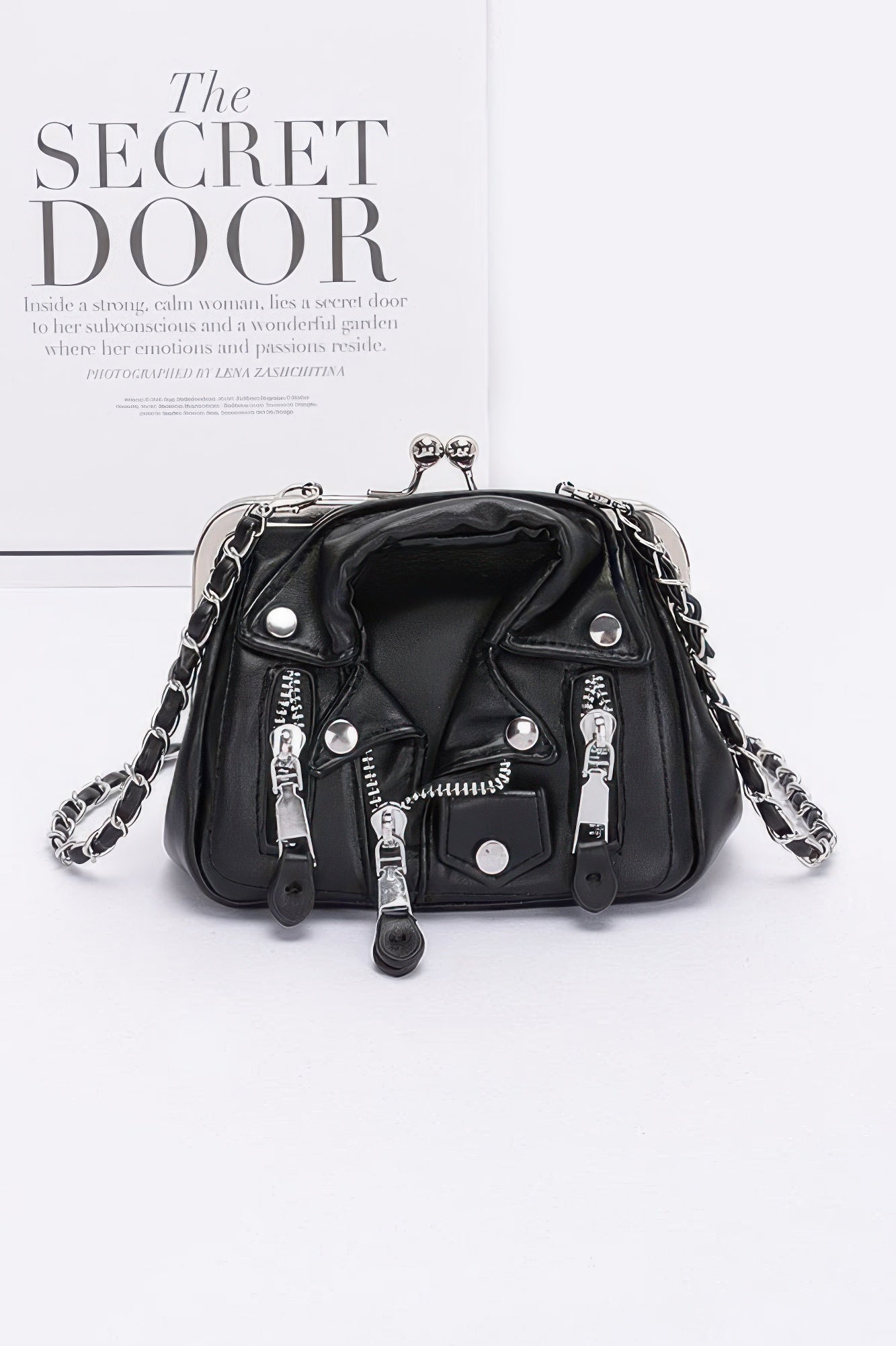 Black faux leather crossbody bag with silver-tone clasp, chain strap and zip details