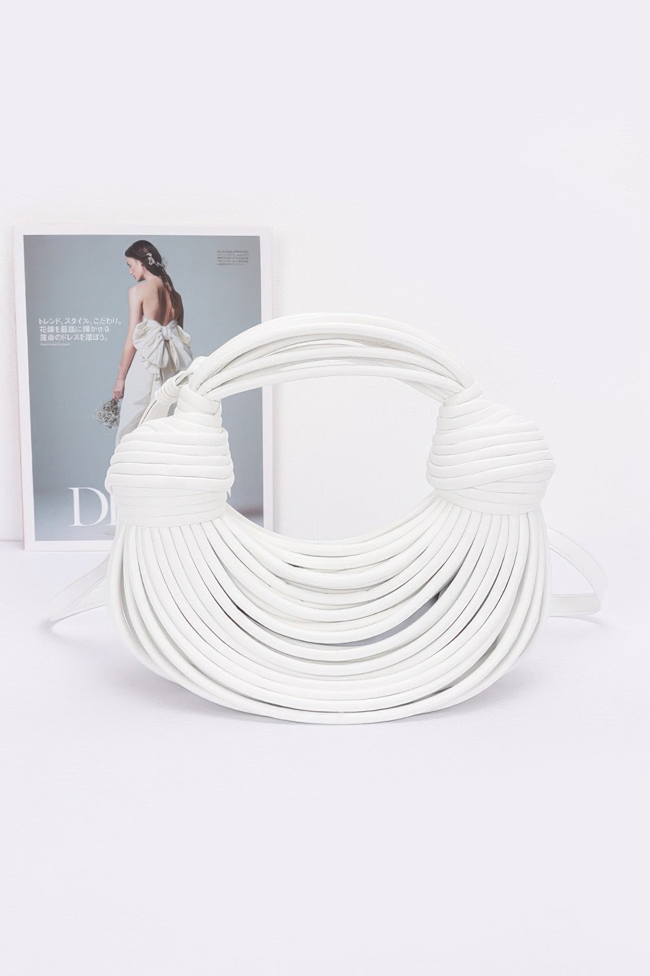 White faux leather rope hobo bag with layered rope texture and knotted handle ends