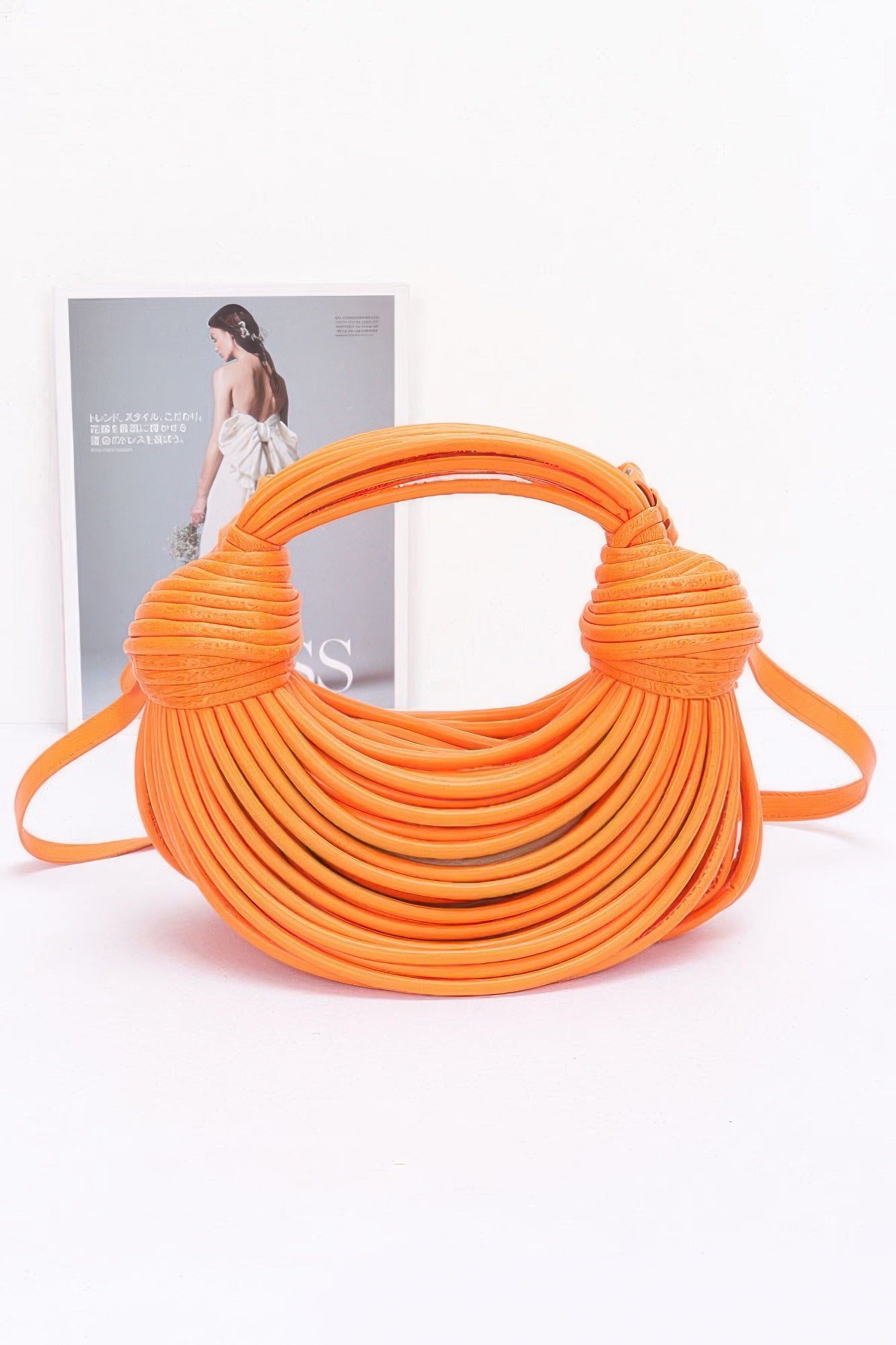 Orange faux leather rope hobo bag with layered rope wrap and knotted handle ends