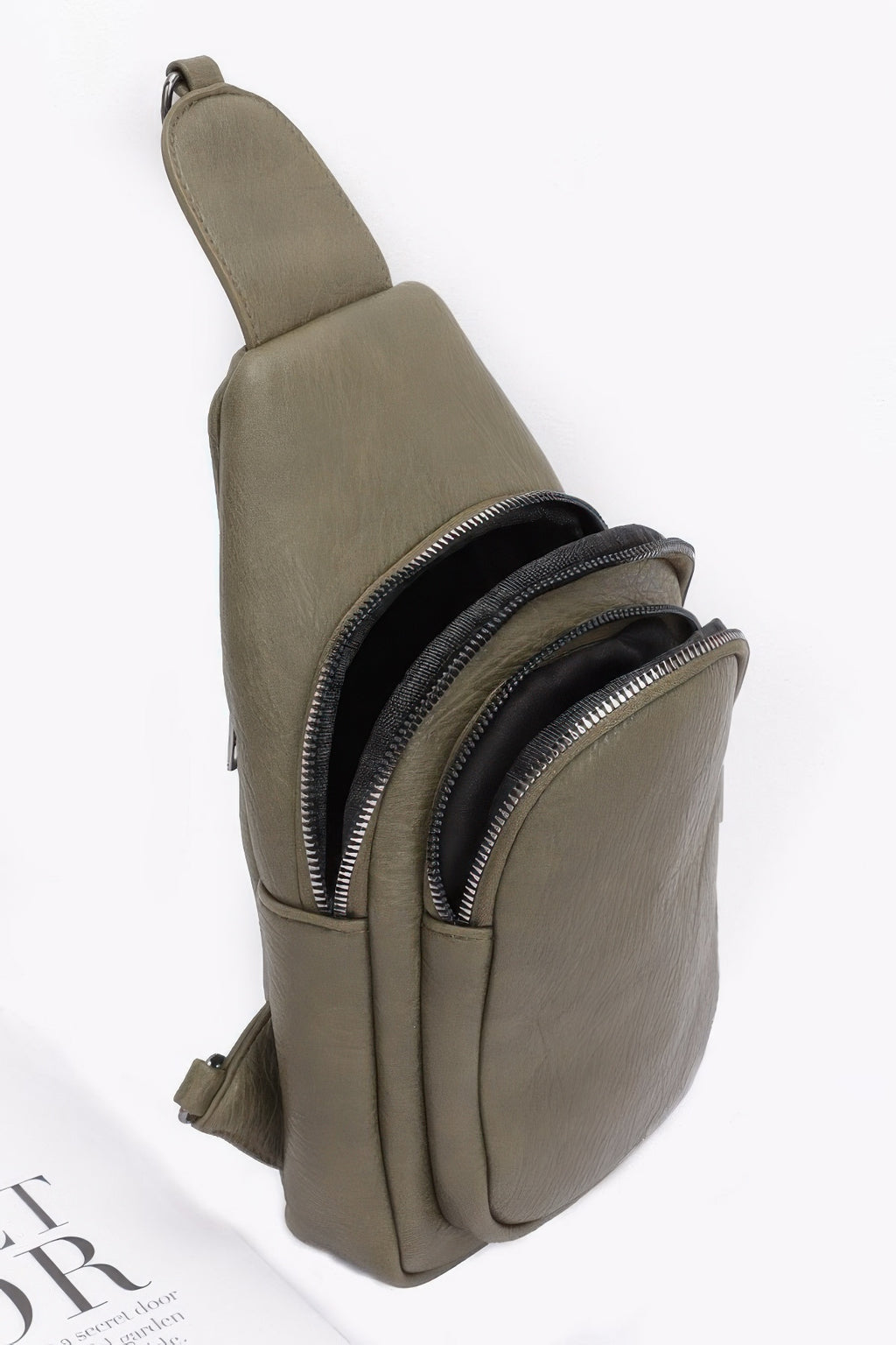 Olive sling bag side view with two zip compartments and black zipper trim