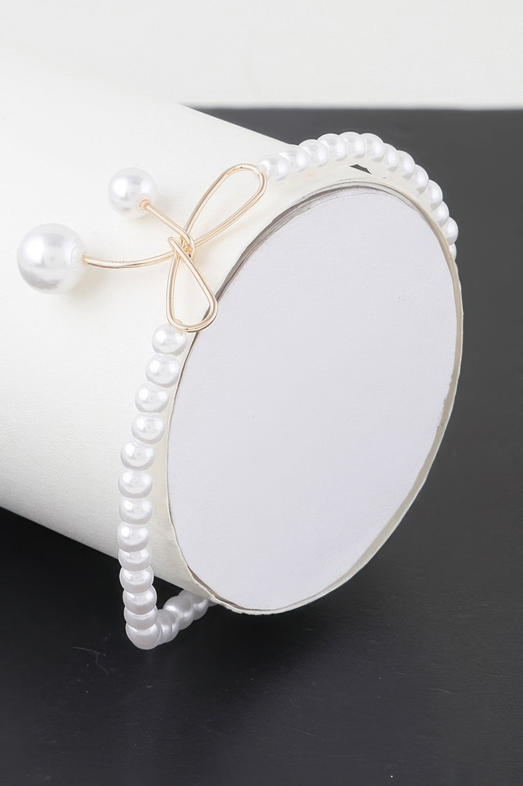 Faux pearl bow bracelet with gold-tone bow clasp and dangling pearl beads