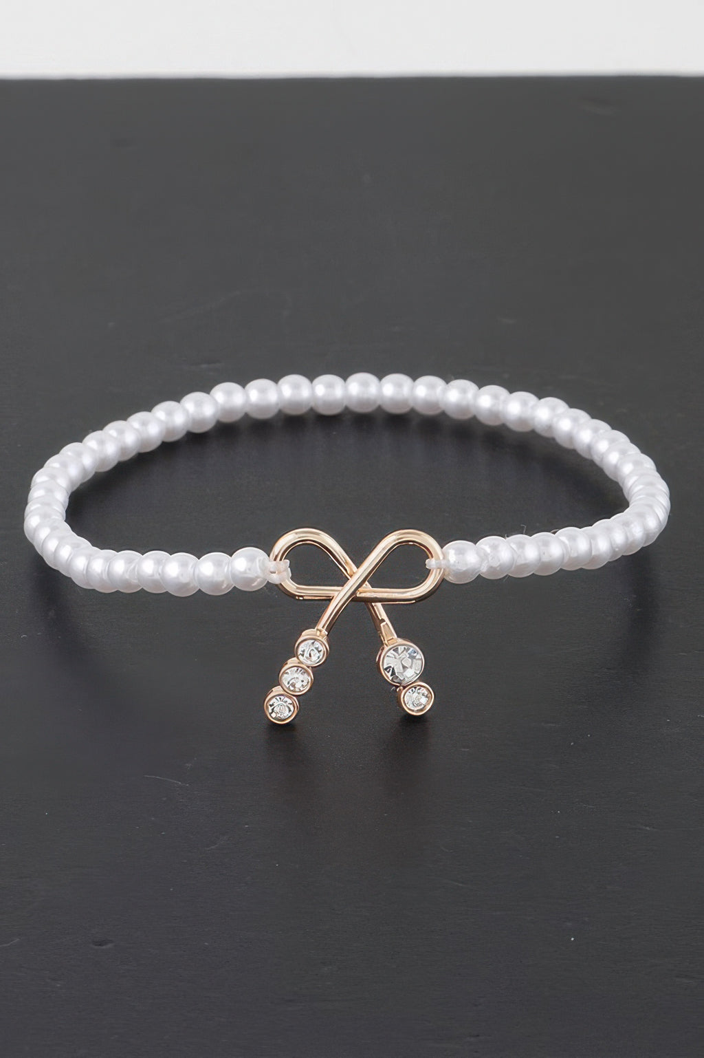 Faux-Perlenarmband mit Schleifenanhänger und Strass, cremeweiße Perlen