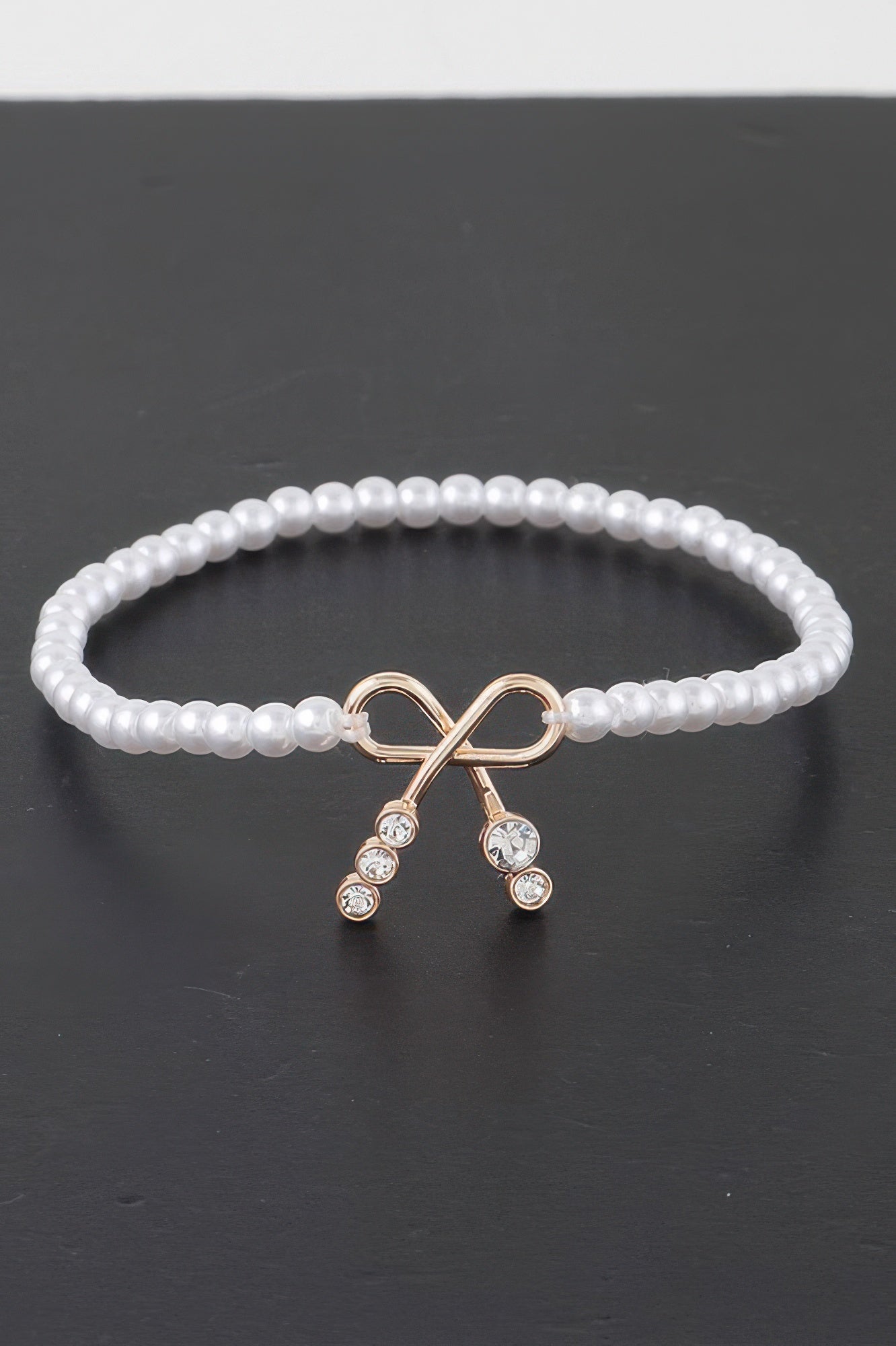 Faux-Perlenarmband mit Schleifenanhänger und Strass, cremeweiße Perlen