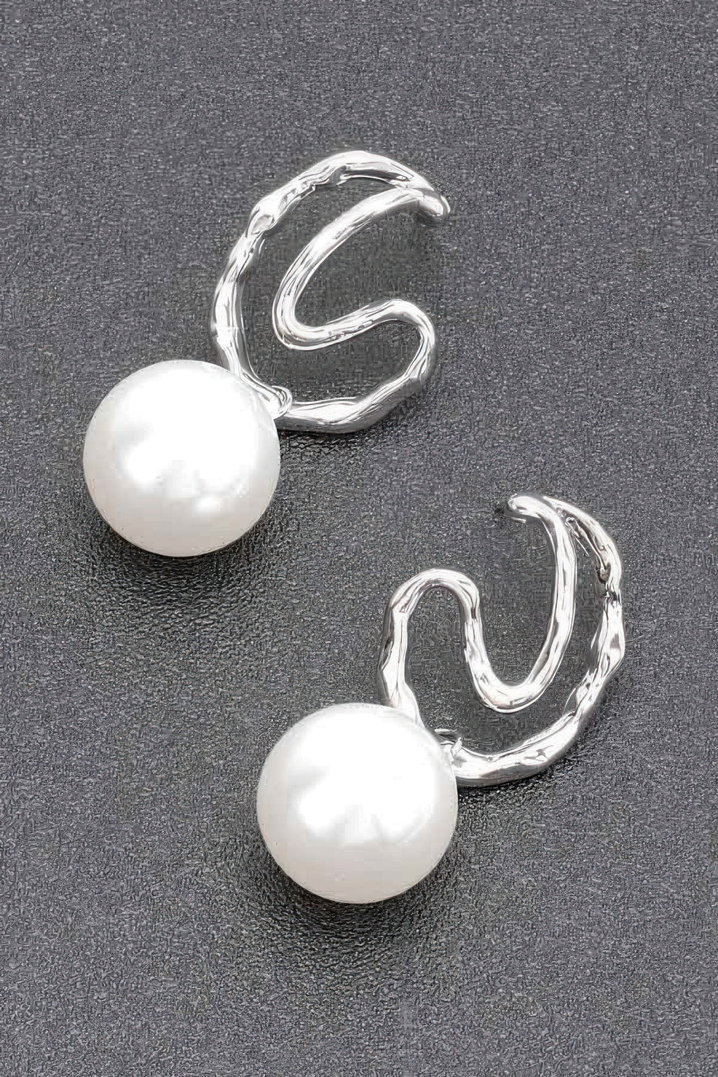 Silver faux pearl earrings with large pearl drops and curved twisted hoops