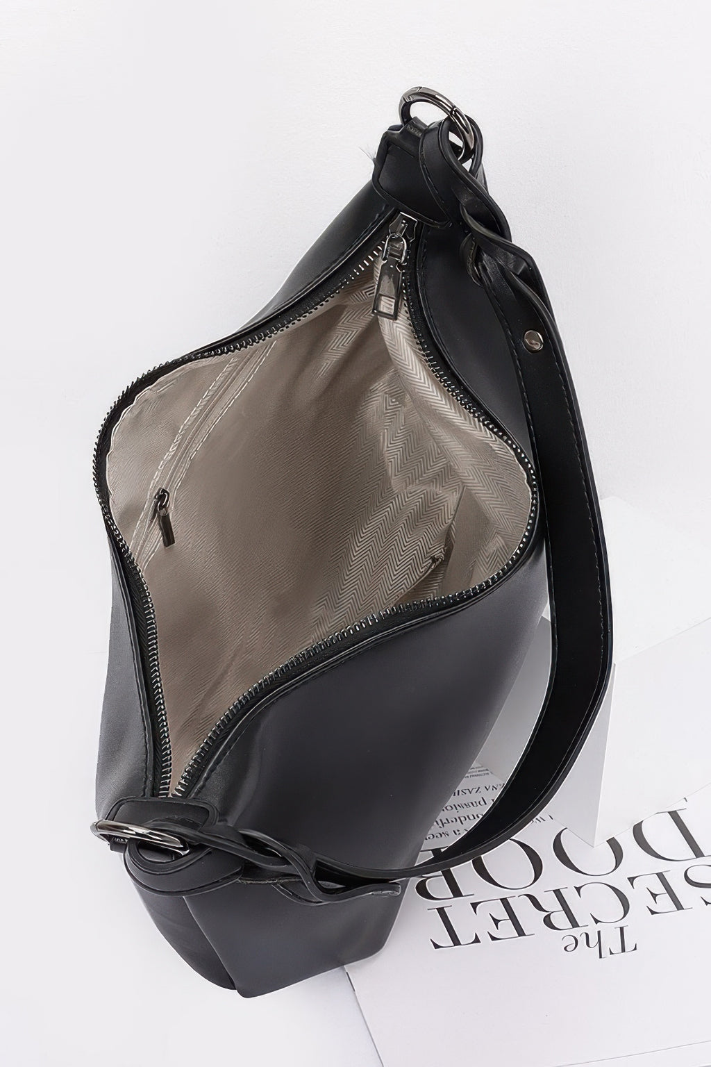 Black shoulder bag with open top showing inner pocket and zip fastening