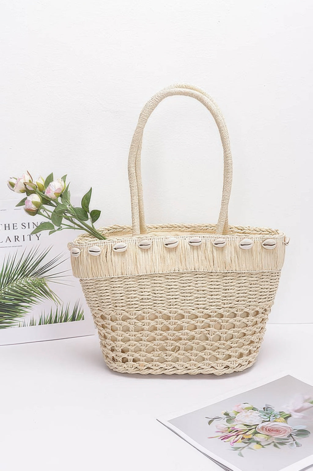 Ivory faux straw shell tote bag with woven texture, rope handles, and button trim