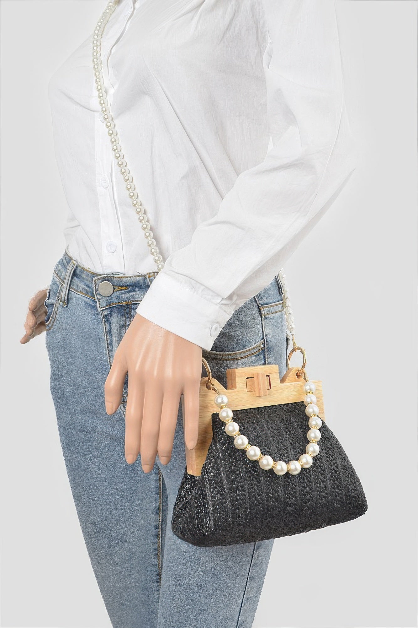 Black faux straw clutch worn crossbody with faux pearl bead chain and wood frame clasp