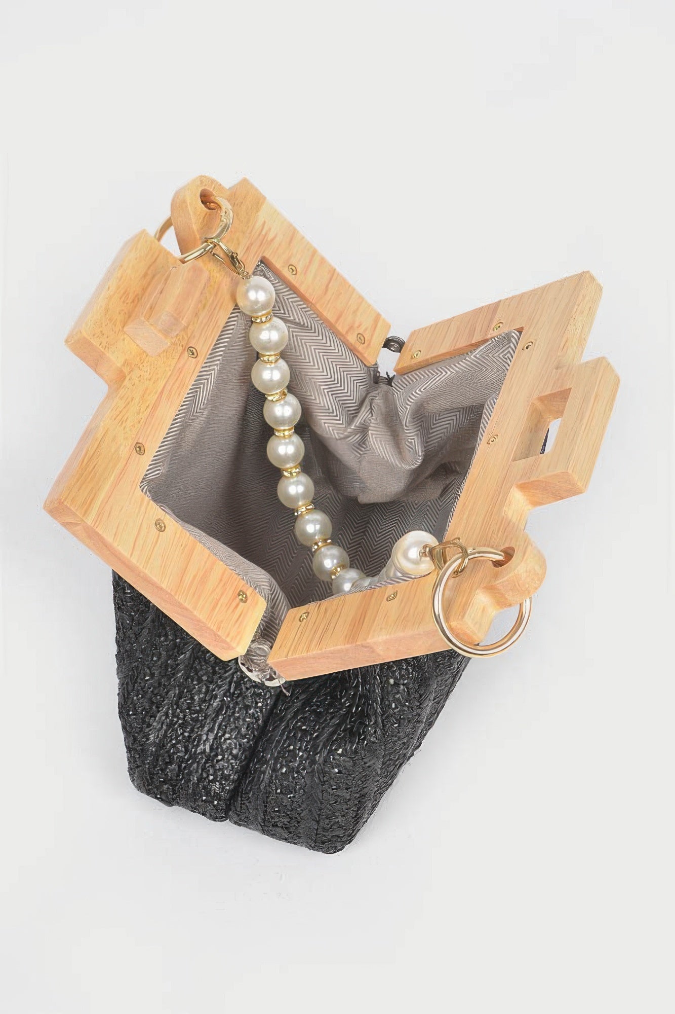 Black faux straw clutch open with wood frame, faux pearl bead chain, and clasp rings