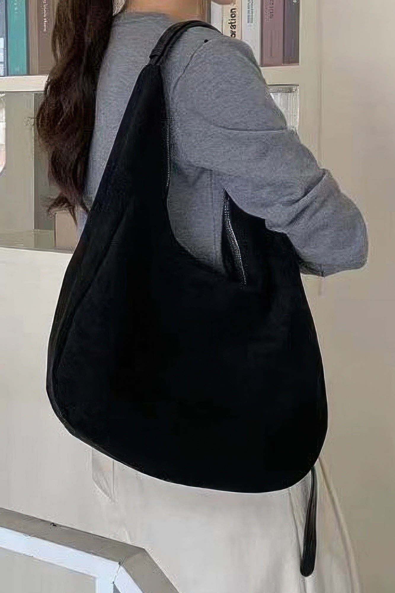 Black faux suede bindle bag with wide strap and rounded hobo shape