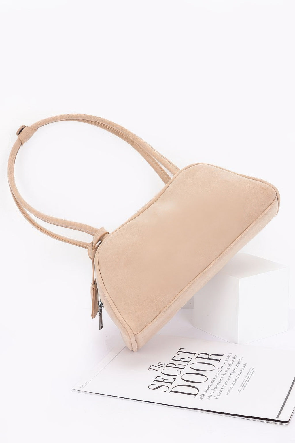 Beige faux suede sport bag angled view with curved handle and zip detail