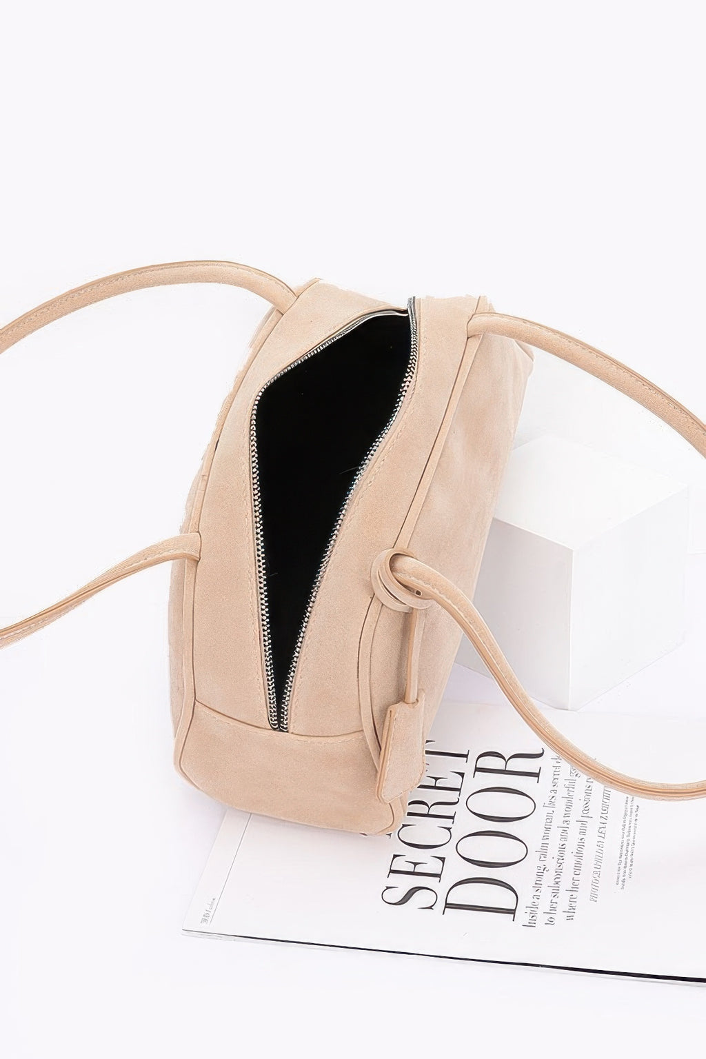 Beige faux suede sport bag showing black-lined interior and zipper closure