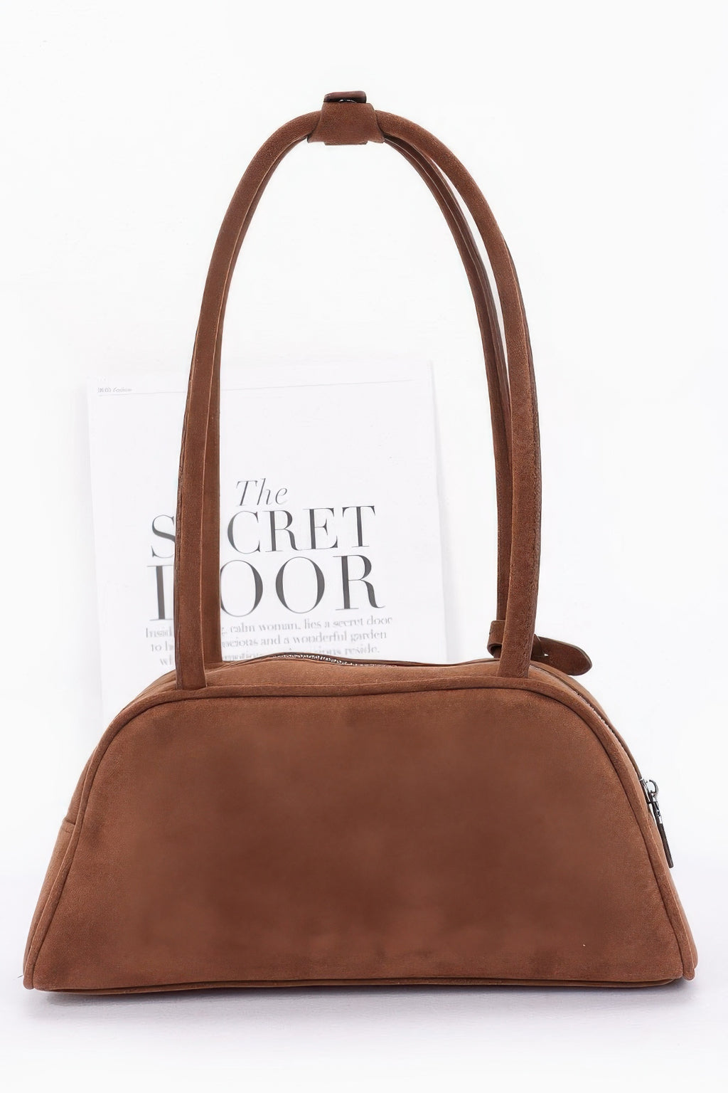 Brown faux suede sport bag with rounded top and hanging charm tag