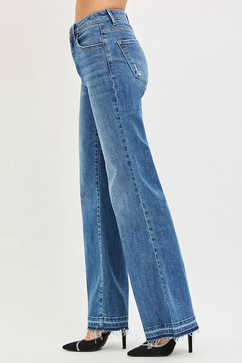 Side view: medium-blue high-rise wide-leg jeans with released, frayed cuff hem