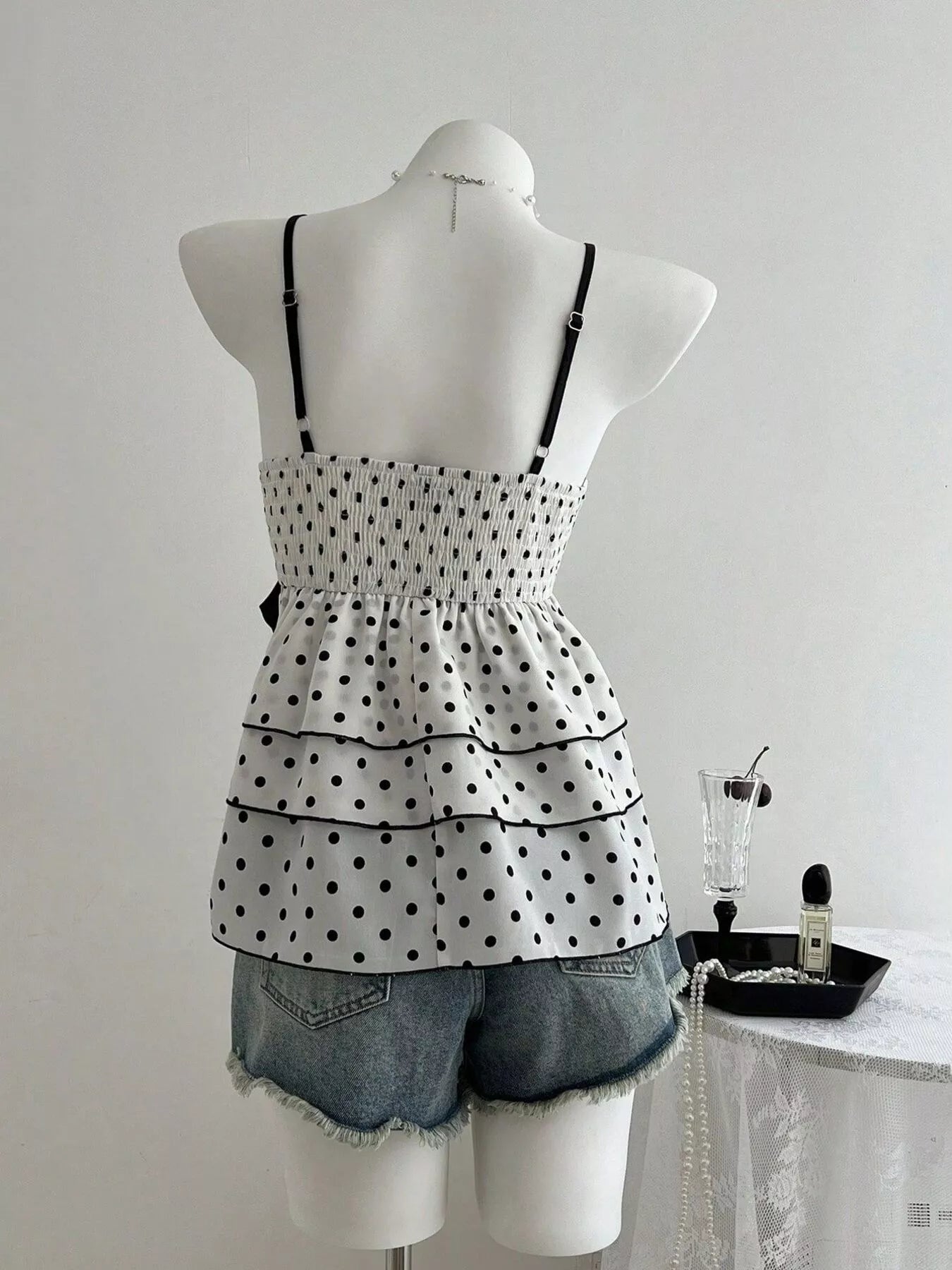 Back view: black polka dot cami with lace trim and tiered ruffle hem