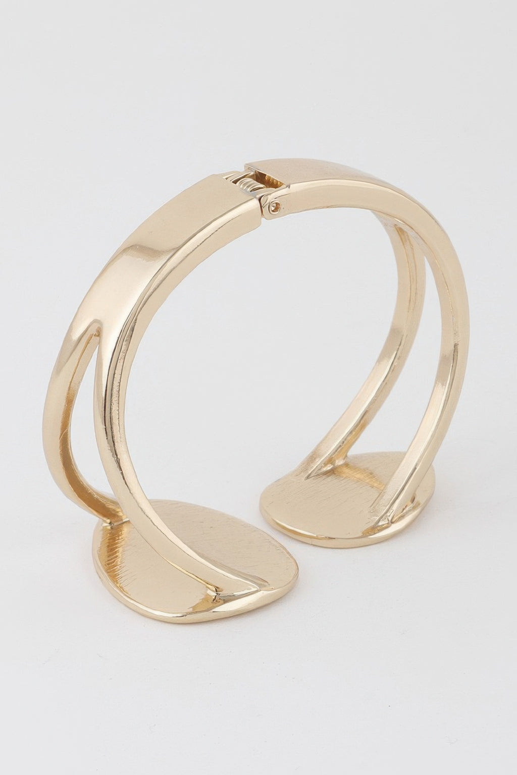 Gold tone open cuff bracelet with curved edges and spring clasp