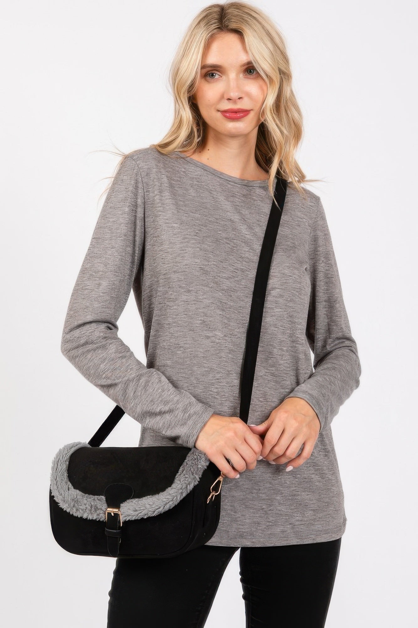 Crossbodybag negra con solapa de fleece blanco, correa ajustable y herrajes dorados