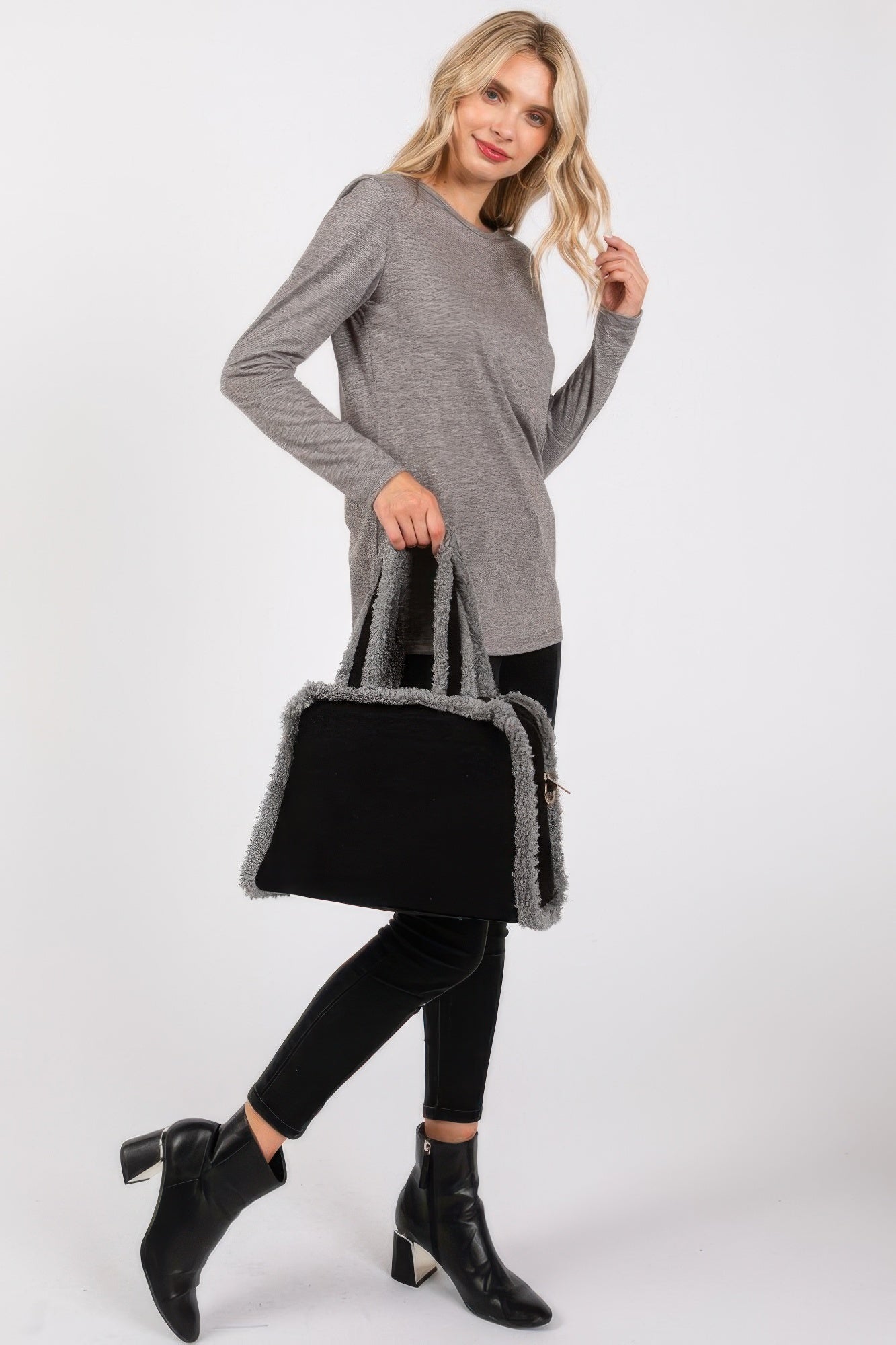 Black crossbody tote with gray fleece trim, shown side view with strap