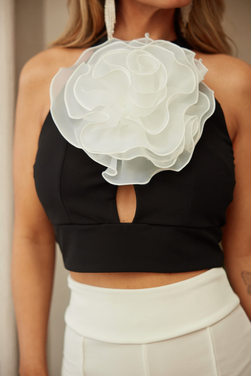 Close-up: black crop top with layered white flower applique