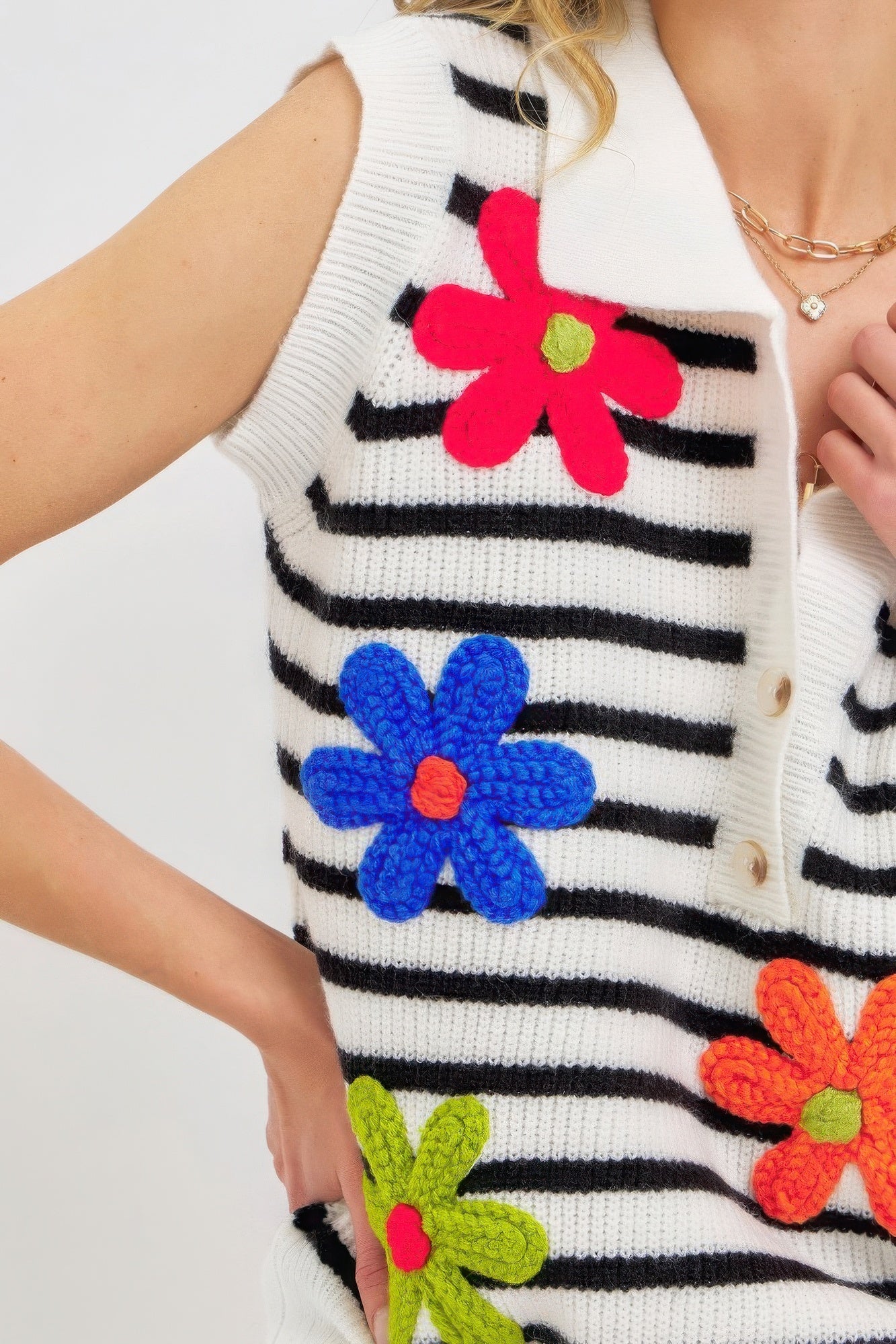 Close-up of ivory-and-black striped knit top with large pink and blue flower patches