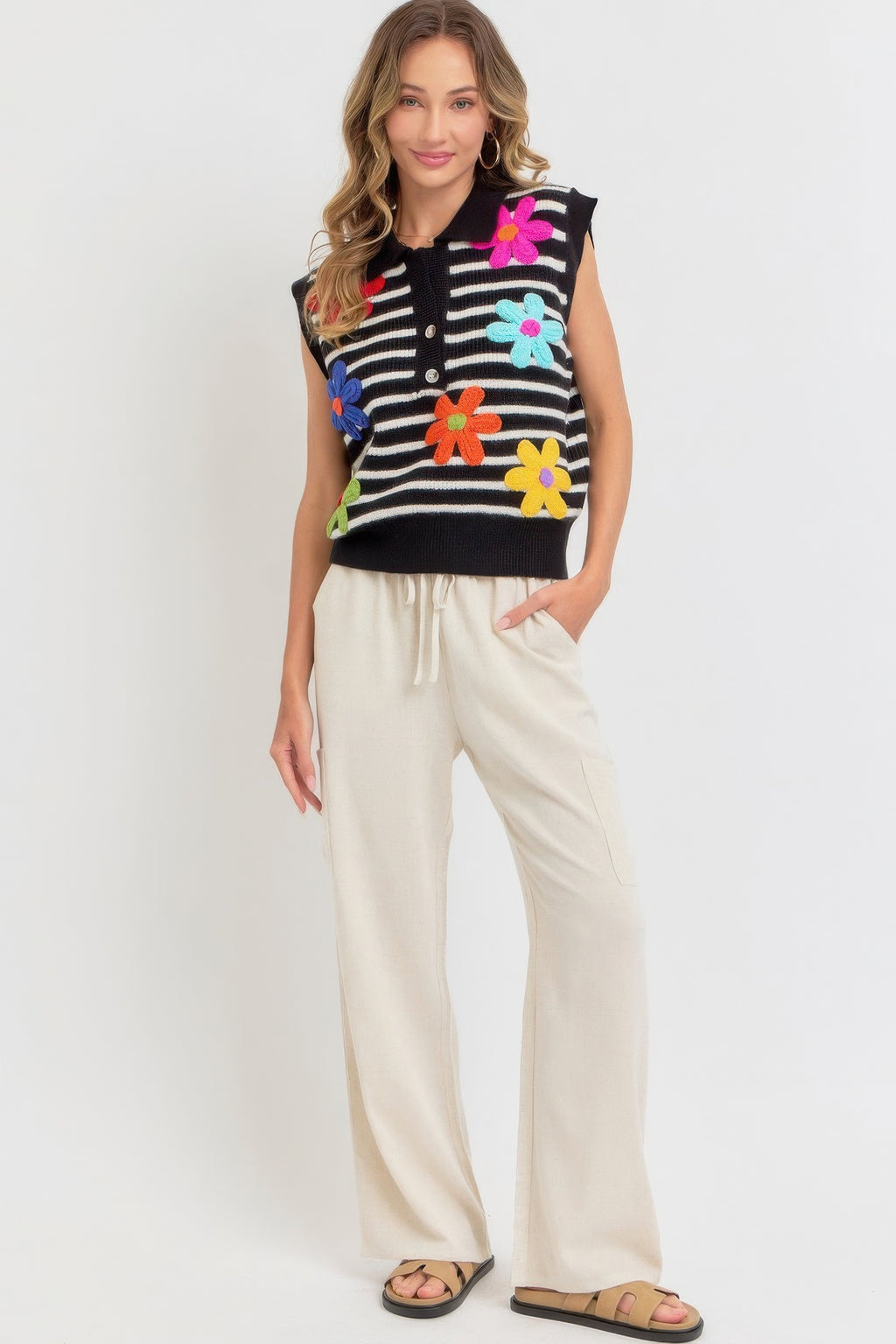 Black-and-ivory striped sleeveless knit top with flower appliqués on the front