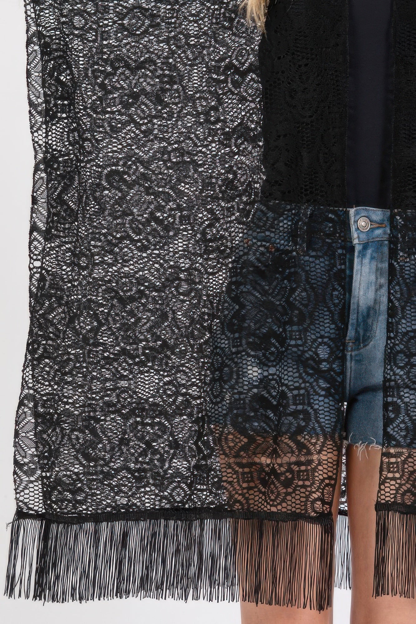Close-up of black lace crochet cover up with floral motifs and dangling tassel trim